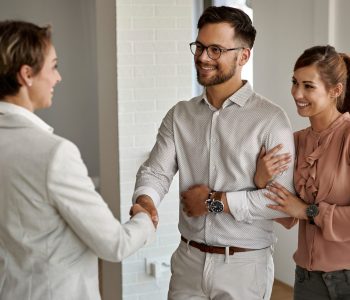 young_happy_couple_shaking_hands_with_real_estate_agent_while_buying_new_apartment_scaled_e1685599101936_2000x1200_4dce58476a