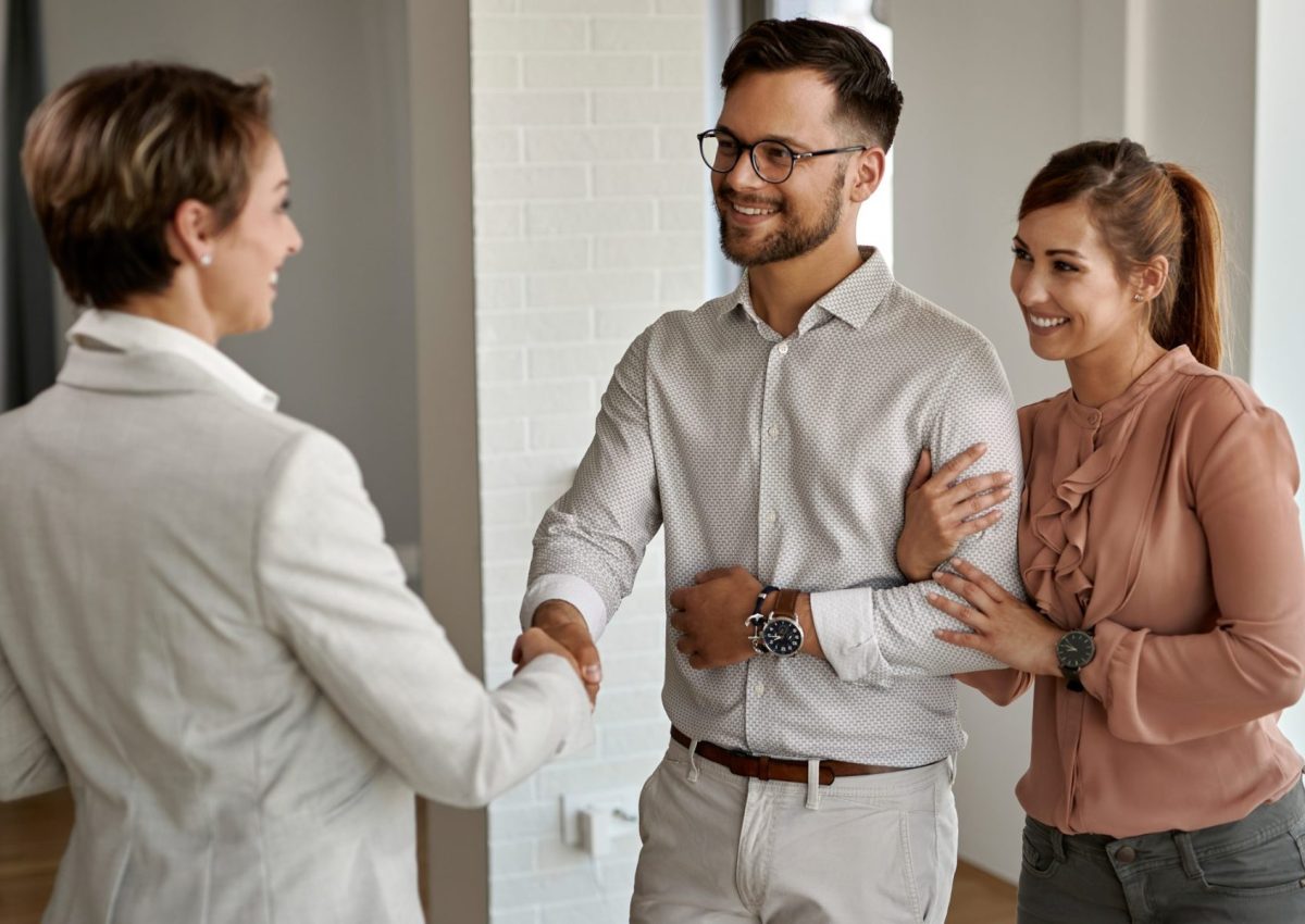 young_happy_couple_shaking_hands_with_real_estate_agent_while_buying_new_apartment_scaled_e1685599101936_2000x1200_4dce58476a